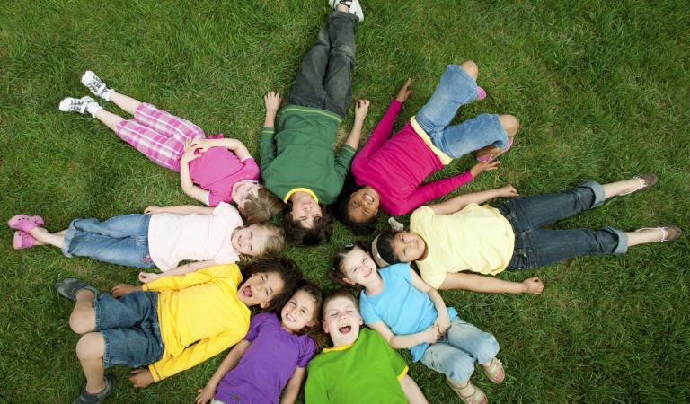 Diverse children outside on the grass having fun. Photo: iStockphoto